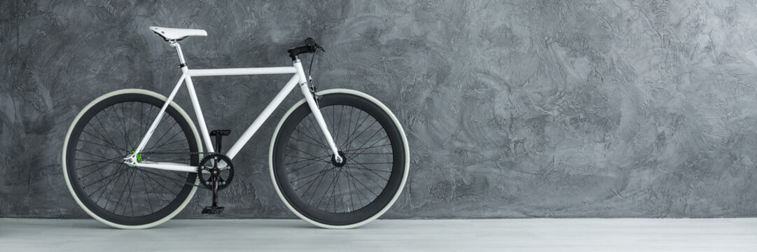 White bicycle against concrete wall