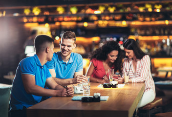 Group of young people meeting in a cafe, using phone