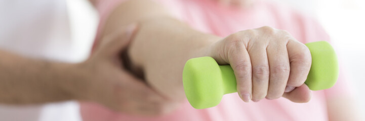 Person holding green dumbbell