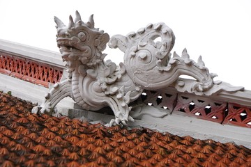 Dragon guardian sculpture atop an ancient Buddhist temple in Hanoi Vietnam