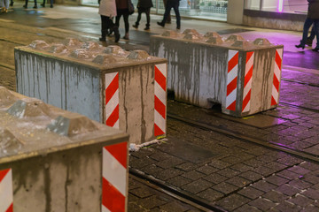 Concrete blocks in the city to protect people from terrorist attacks, in the background people