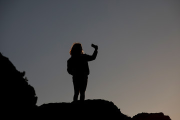 Young girl on mountain taking selfie