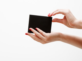 Flat lay, top view. Beauty and fashion concept. Beautiful female hands with red manicure. Minimal style. Minimalist photography. Composition with girl's hand holding discount card on white background