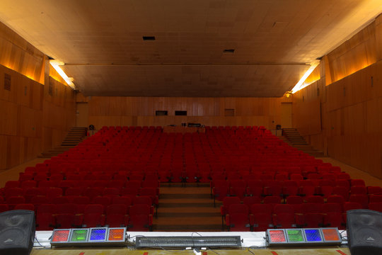 Empty old theatre with red seats, view from stage