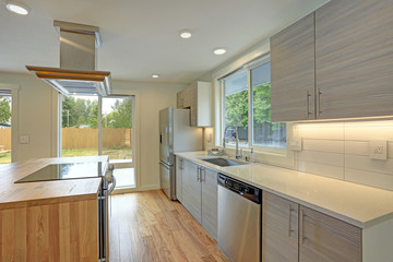 Newly remodeled kitchen boasts kitchen island with a hood.