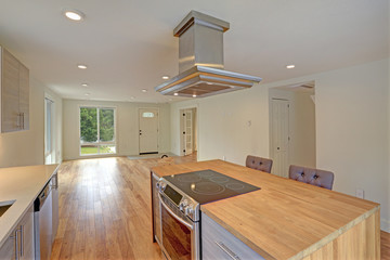 Newly remodeled kitchen boasts kitchen island with a hood.