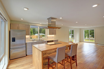 Newly remodeled kitchen boasts kitchen island with a hood.