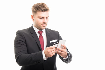 Handsome manager paying with smartphone and card