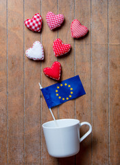 cup on lying on side with Europe Union flag and heart shapes