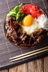 Japanese cuisine: gyudon beef with rice and onion. Vertical top view