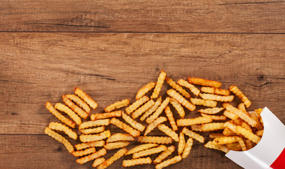French fries spilled on the table from paper holder - copy space