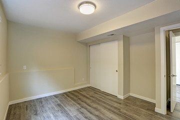 Bright beige empty room with grey hardwood floor