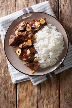 Philippine food: Salpicao beef with garlic and rice closeup on a plate. Vertical top view