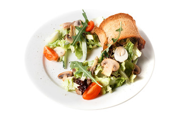 Close-up homemade fresh vegan vegetable salad with mushroom, quail egg, arugula, tomato, cucumber and bread toast. Round plate. Isolated on white