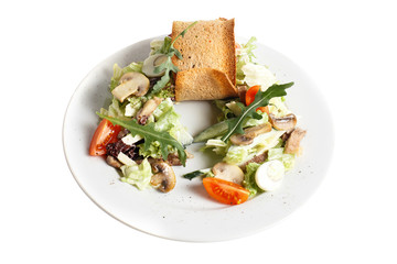 Diet homemade fresh vegan vegetable salad with mushroom, quail egg, ruccola, tomato, cucumber and bread toast. Round plate. Isolated on white