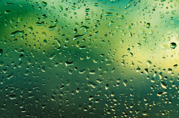 Rainy wet green eco seasonal summer natural blurred background with water drops