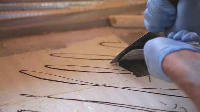 Cook turns ice cream on the ice plate into rolls