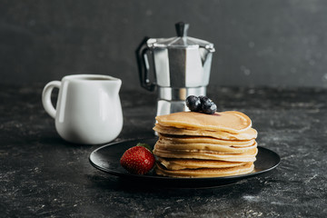 stack of freshly baked pancakes with mocha pot and milk jug