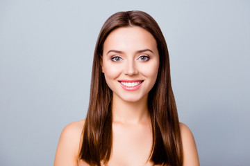 Naklejka premium Close up portrait of beautiful pretty cute lovely smiling woman with perfect smooth flawless skin, isolated on grey background