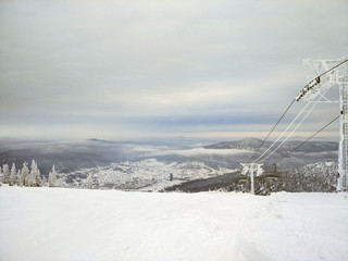 Panorama of ski resort, slope. Cold weather, the supports of the cable car in the ice.