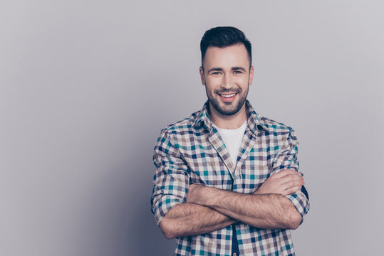 Portrait with copy space of young attractive, stunning, smiling man having his hands crossed, looking at camera, standing over grey background