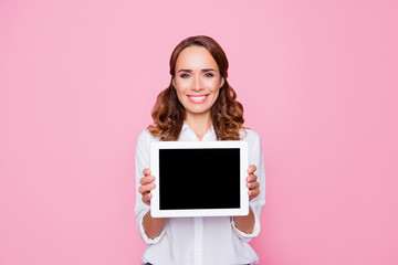 Beautiful charming smiling happy woman with beaming smile is showing a tablet with empty black screen, isolated on bright pink background