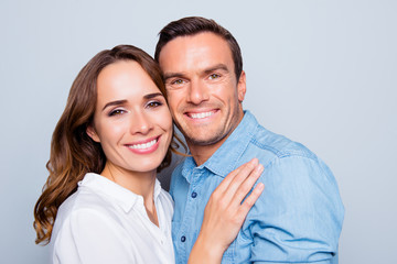 Close up portrait of mature, adult, attractive, cute, lovely couple with beaming smiles, check to check face, looking at camera,   over grey background