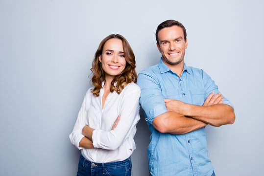 He vs she happy together. Close up portrait of attractive, caucasian, lovely, cute, adult couple in casual outfit  looking at camera standing with crossed arms over grey background