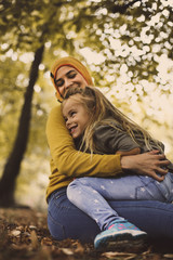 Young Muslim mother in hug with daughter.