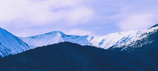 Mountain snow peak, beautiful natural winter backdrop. Ice top of the hill, blue sky background. Alpine landscape.