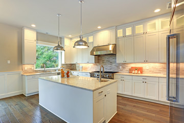 Luxury white kitchen with large kitchen island.