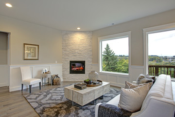 Luxury living room features corner stone fireplace