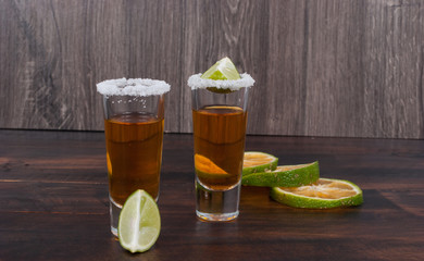Tequila with lemon and salt on the wooden background