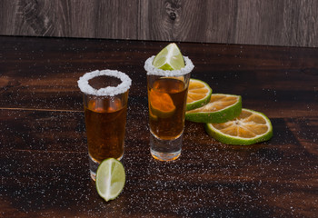Tequila with lemon and salt on the wooden background