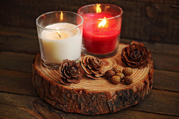 Red and white candle lit on wood