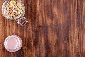 Obraz na płótnie Canvas Healthy breakfast. Ceramic bowl with oat flakes, dried fruits, nuts on wood background
