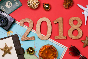 Travel concept on wooden table.Christmas decorations,camera, map and wooden numbers 2018