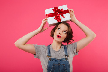 Portrait of a cheerful young girl holding present box