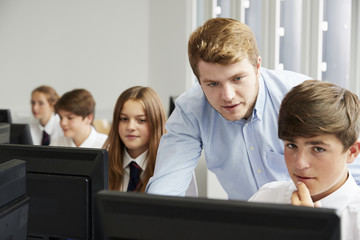 Teenage Students Wearing Uniform Studying In IT Class