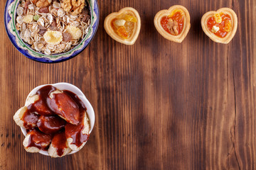 Healthy breakfast. Ceramic bowl with oat flakes, dried fruits, nuts on wood background