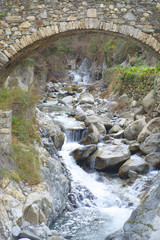 Fototapeta na wymiar old stone bridge over a waterfall