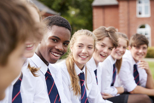 Group Of Teenage Students In Uniform Outside School Buildings