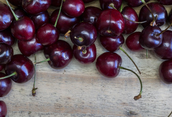 Top view of cherries heap isolated on rustic wooden background