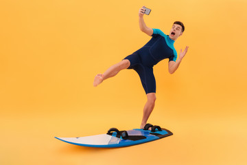 Picture of Playful surfer in wetsuit using surfboard