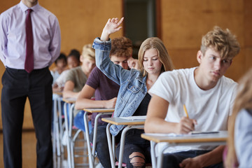 Teenage Student Sitting Examination Asking Teacher Question