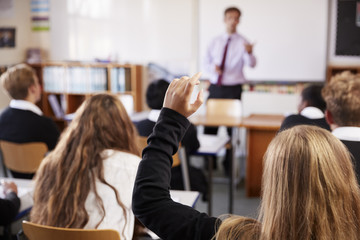 Female Student Raising Hand To Ask Question In Classroom - Powered by Adobe