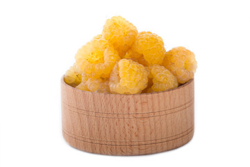 yellow raspberry in wooden cup isolated