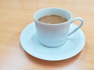 A cup of coffee on wooden table in cafe or meeting room. Picture with copy space