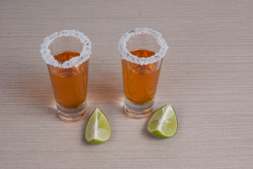 Tequila with lemon and salt on the wooden background