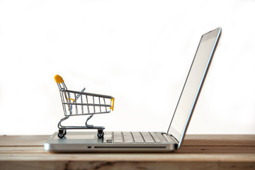 Small Shopping Cart On Laptop With Copyspace : Online Shopping Concept. E-commerce.